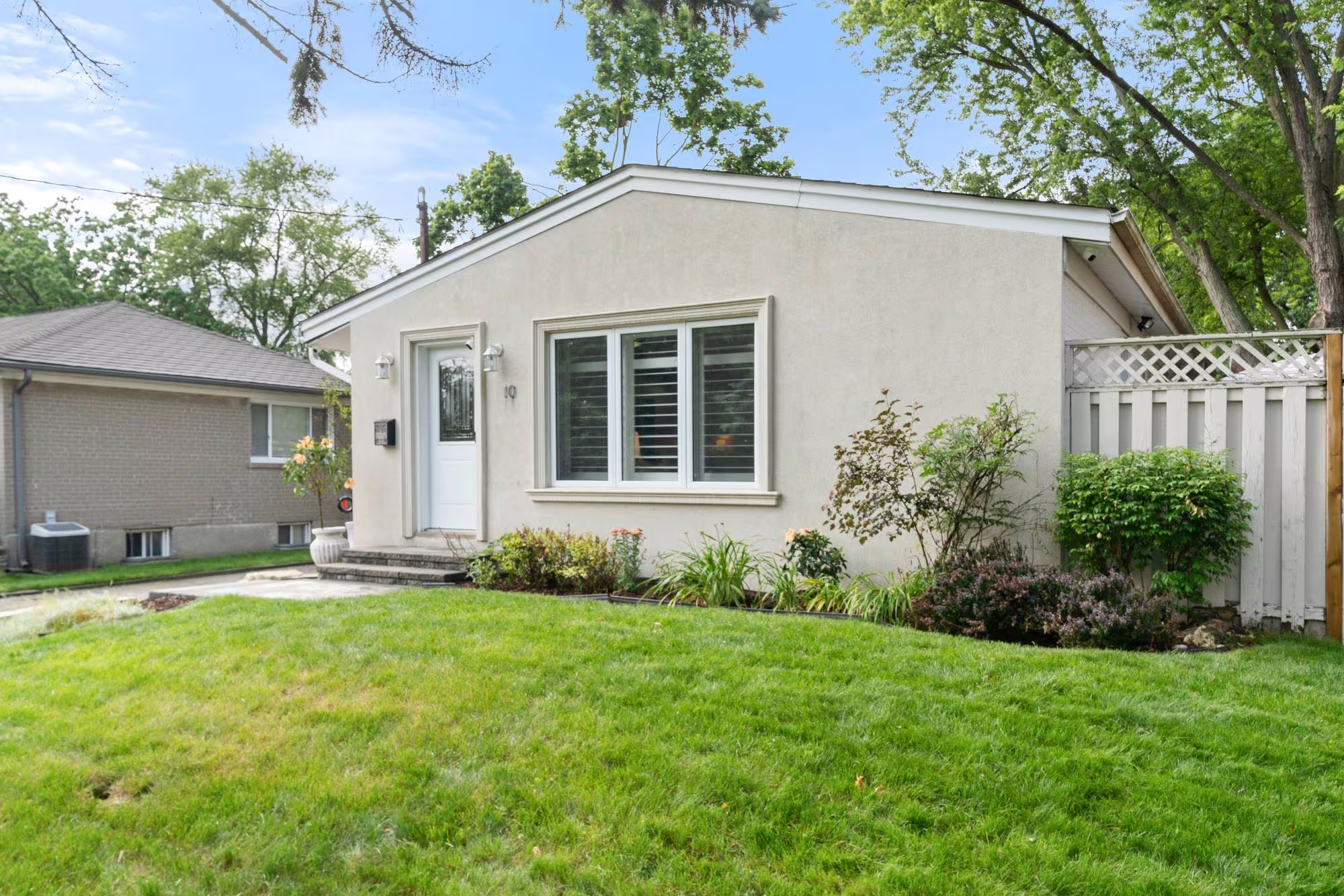 A stucco bungalow with mature landscaping in Central West Ajax, near Old Pickering Village