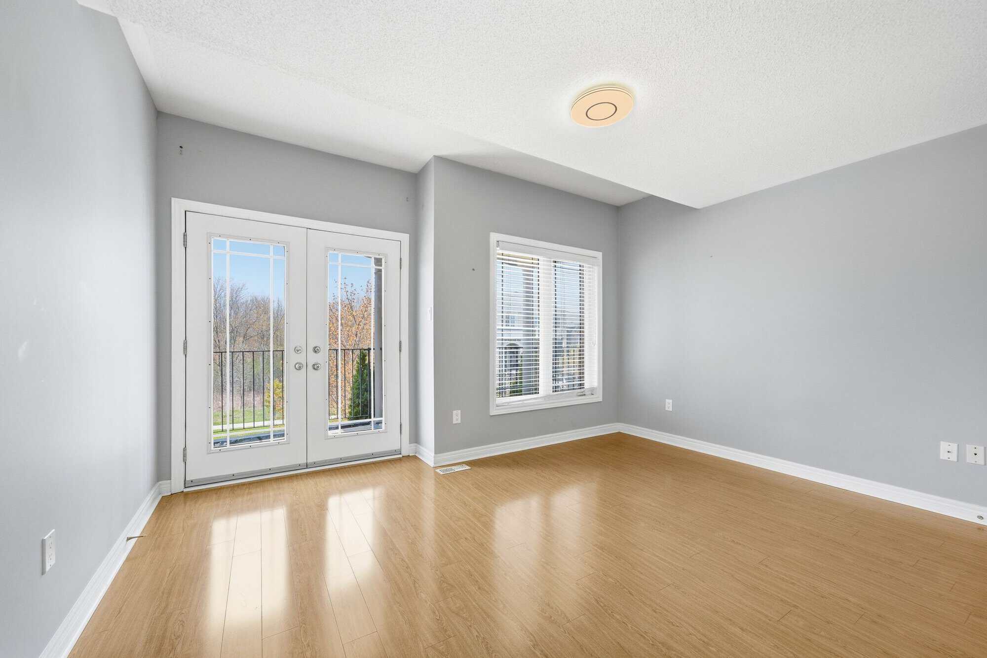 Bedroom with French doors opening to the upper covered balcony at 131 Rushworth Drive, Ajax