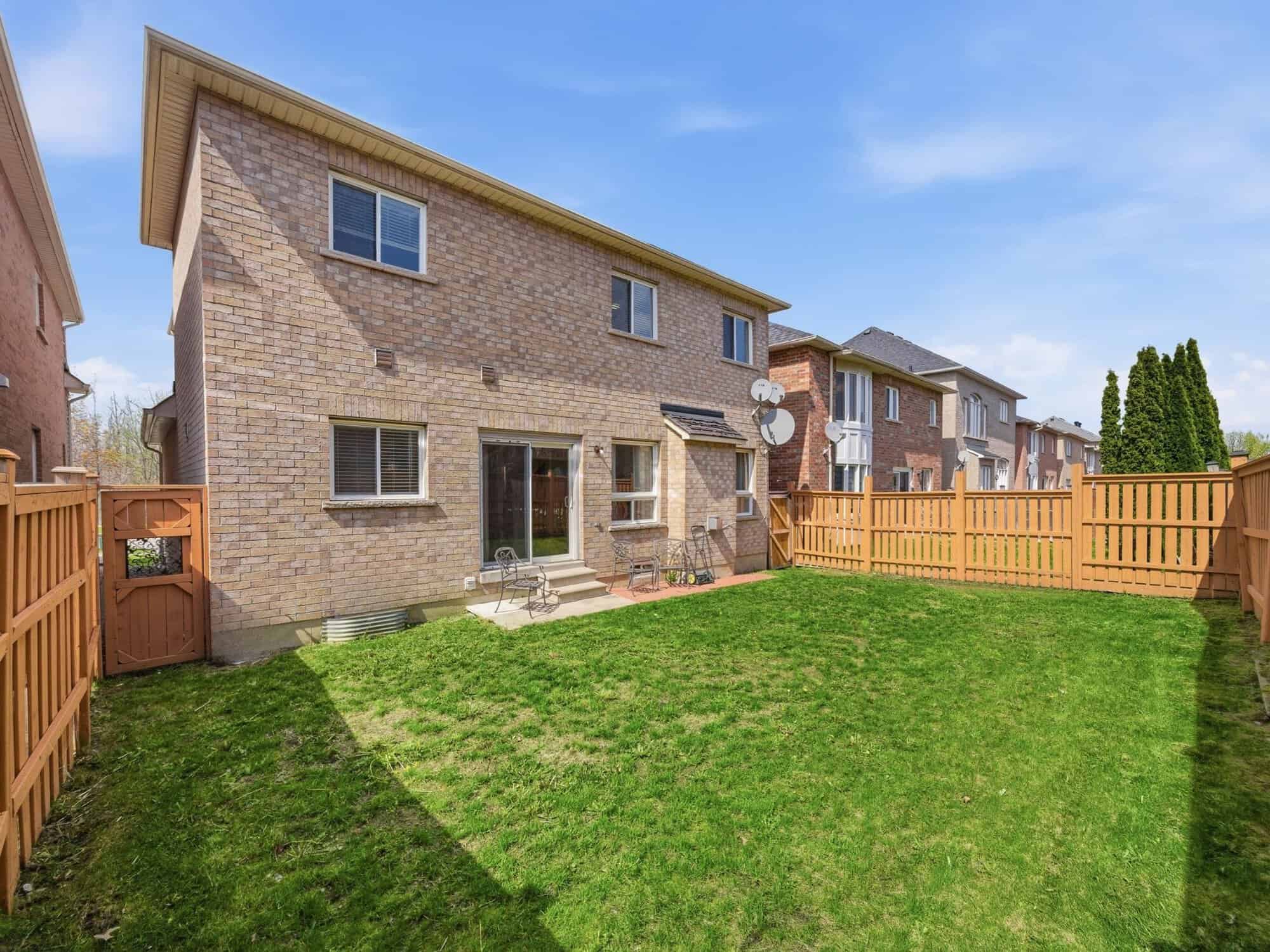 Rear exterior of 131 Rushworth Drive, Ajax, with brick facade and fenced yard