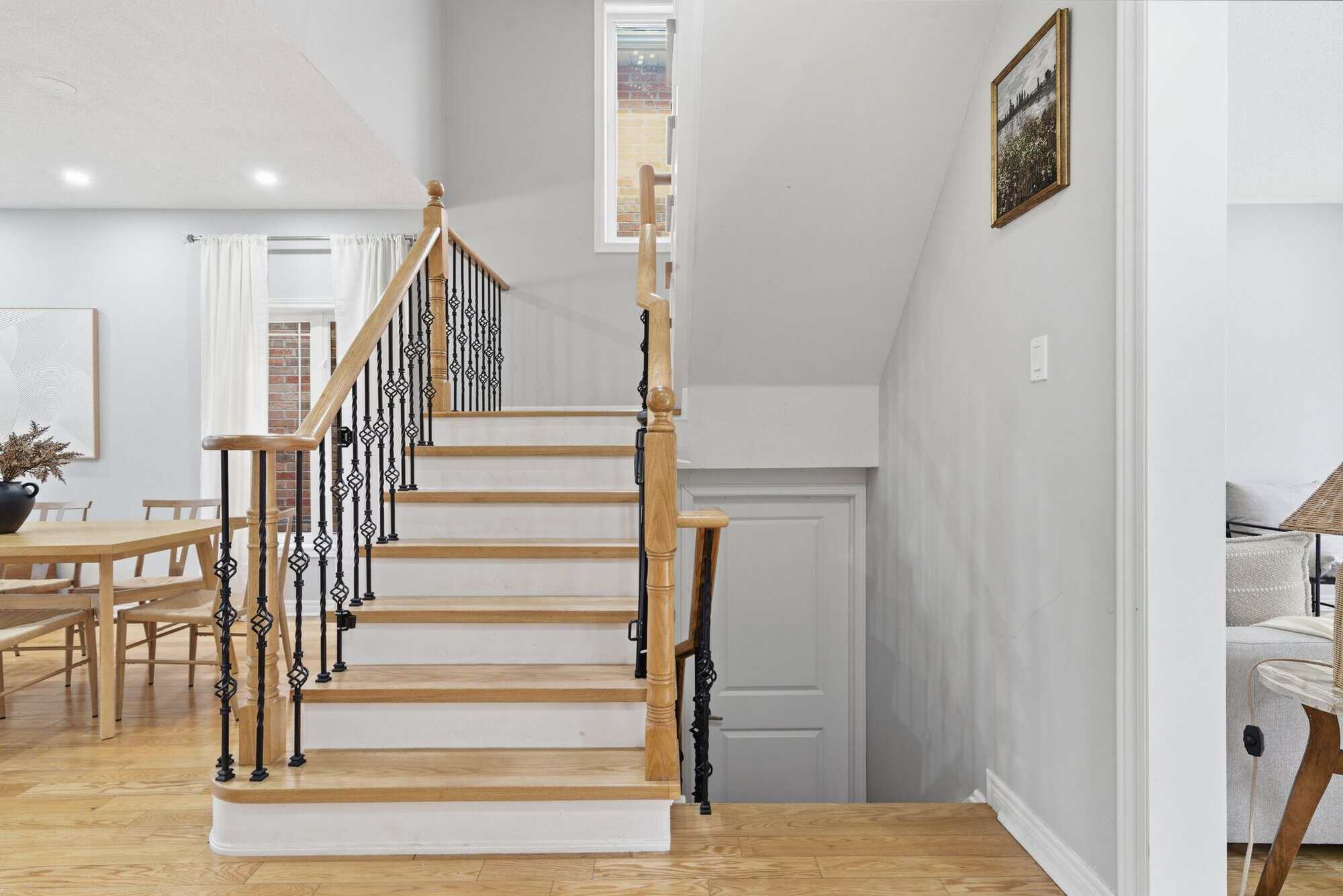 Staircase at 131 Rushworth Drive, Ajax, with oak treads and wrought iron basket-weave spindles