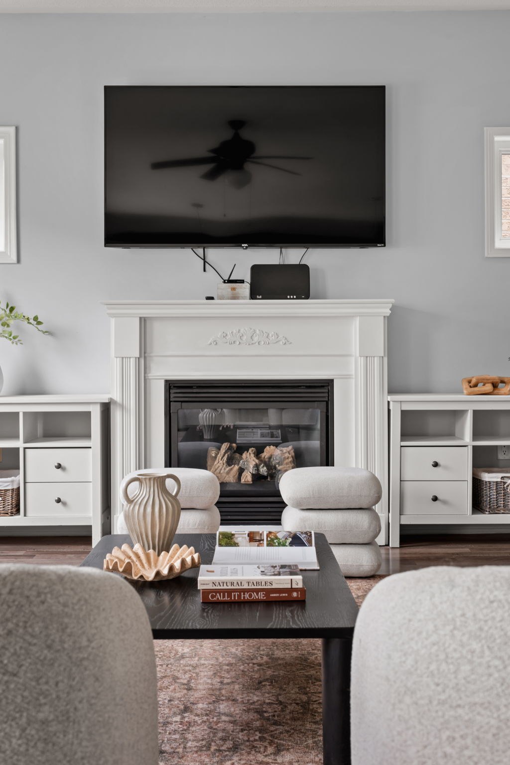Family room fireplace seating detail at 1683 Finkle Drive, Oshawa, with stacked pouf ottomans and a coffee table