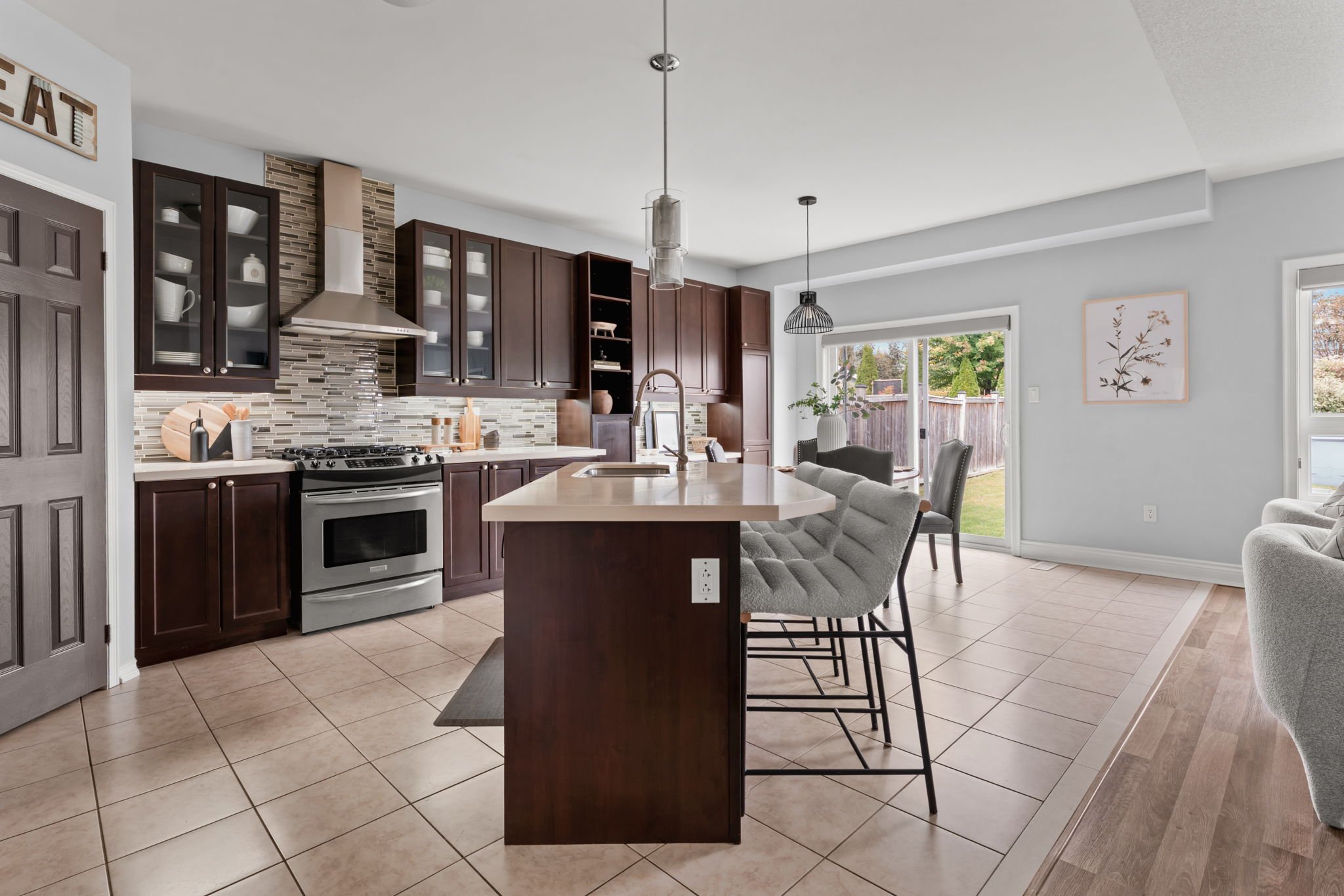 Eat-in kitchen at 1683 Finkle Drive, Oshawa, with dark cabinetry, a large island, quartz counters and a view to the living room