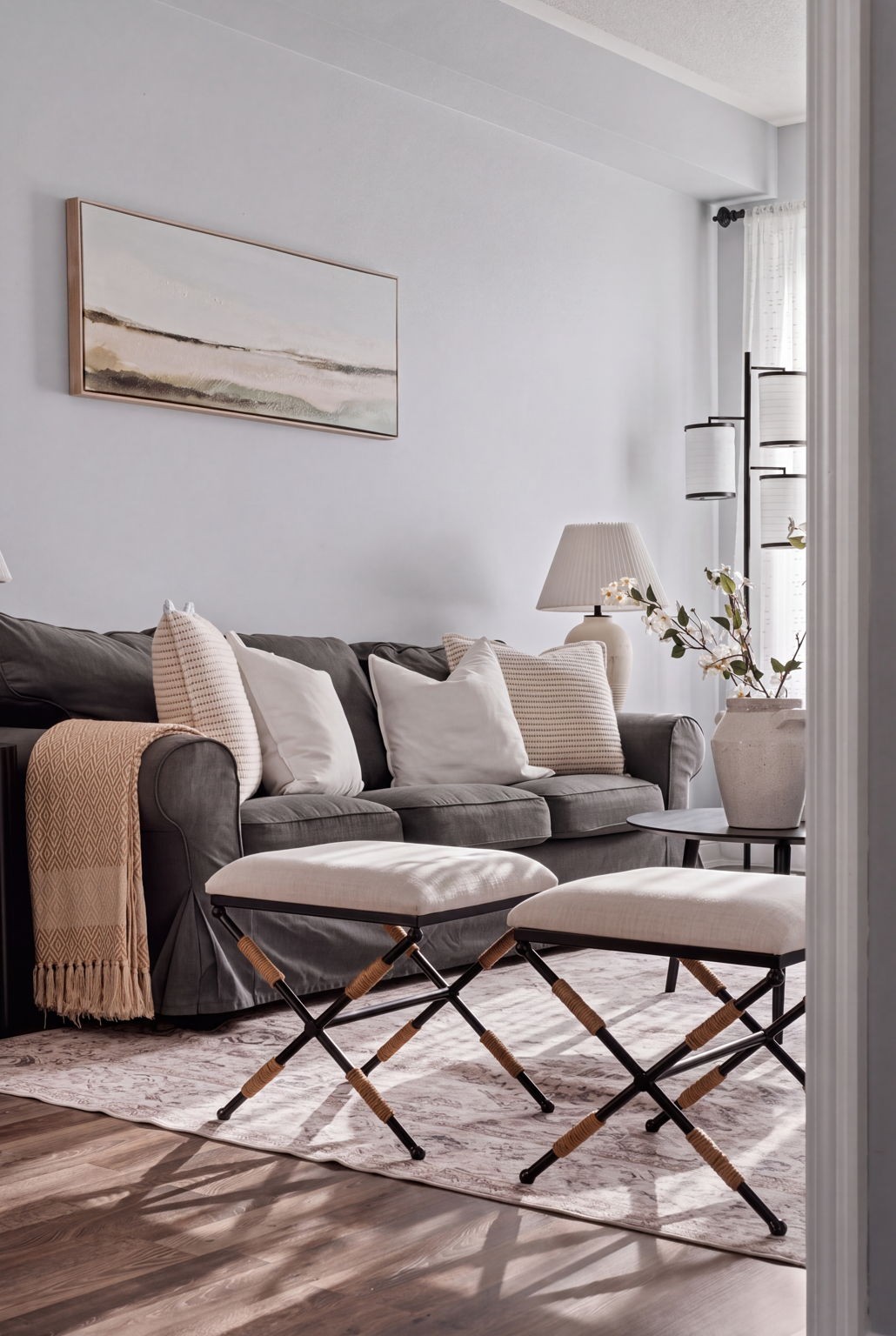 Sunlit living room styling detail at 1683 Finkle Drive, Oshawa, with a gray sofa and X-frame ottomans