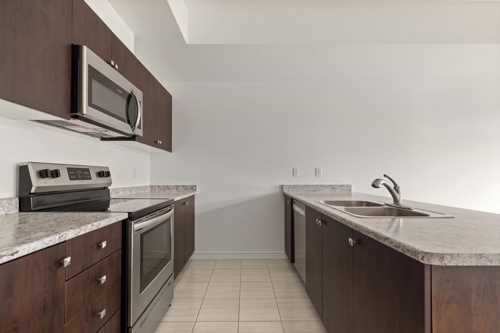 Kitchen at 2598 William Jackson Dr, Pickering, with dark wood cabinetry and a breakfast bar