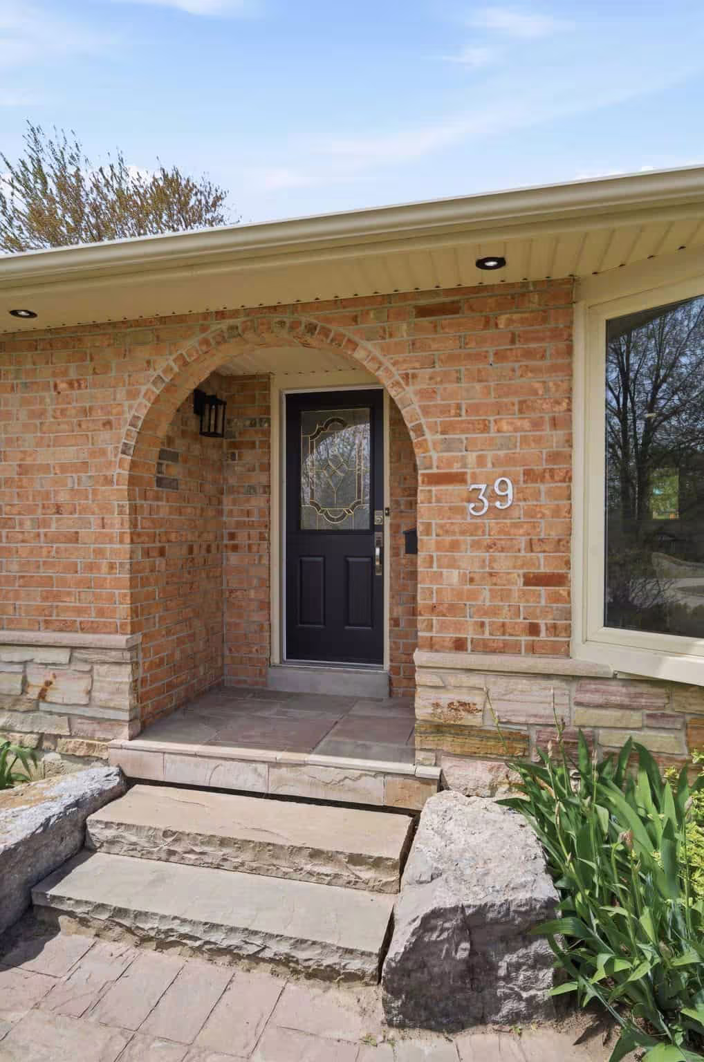 Arched brick front entry at 39 Anstead Crescent, South Ajax, with a black front door and stone steps