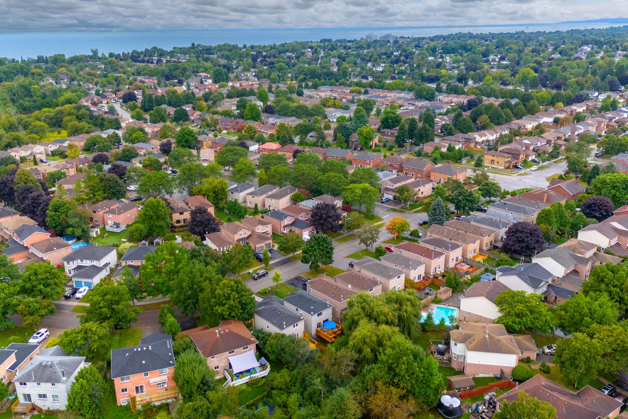 Aerial bird's-eye view of a South Ajax neighbourhood near Cluett Drive, with Lake Ontario visible in the distance