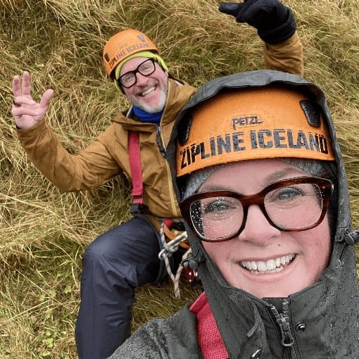 Laura McBride and her husband smiling in helmets at Zipline Iceland after a thrilling ride.
