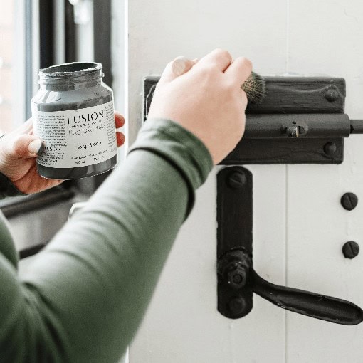 Hand painting a vintage door latch with black Fusion Mineral Paint.
