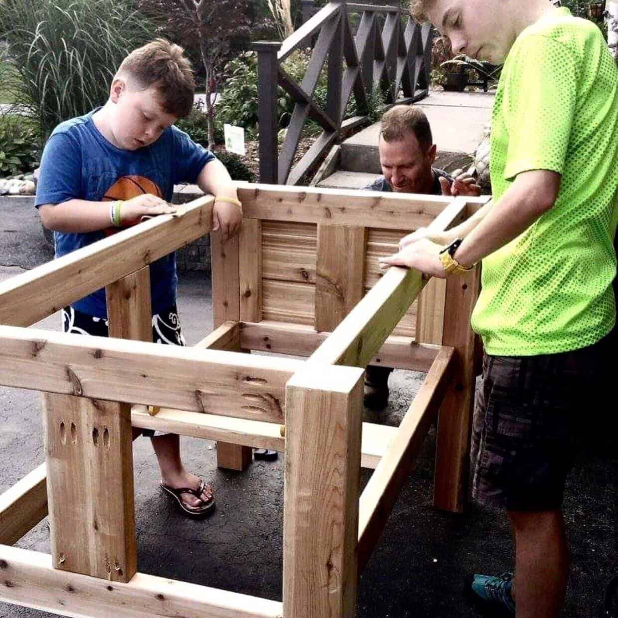 Laura McBride’s husband and two sons building the first Junior Green Thumbs garden box by hand for their son's classroom