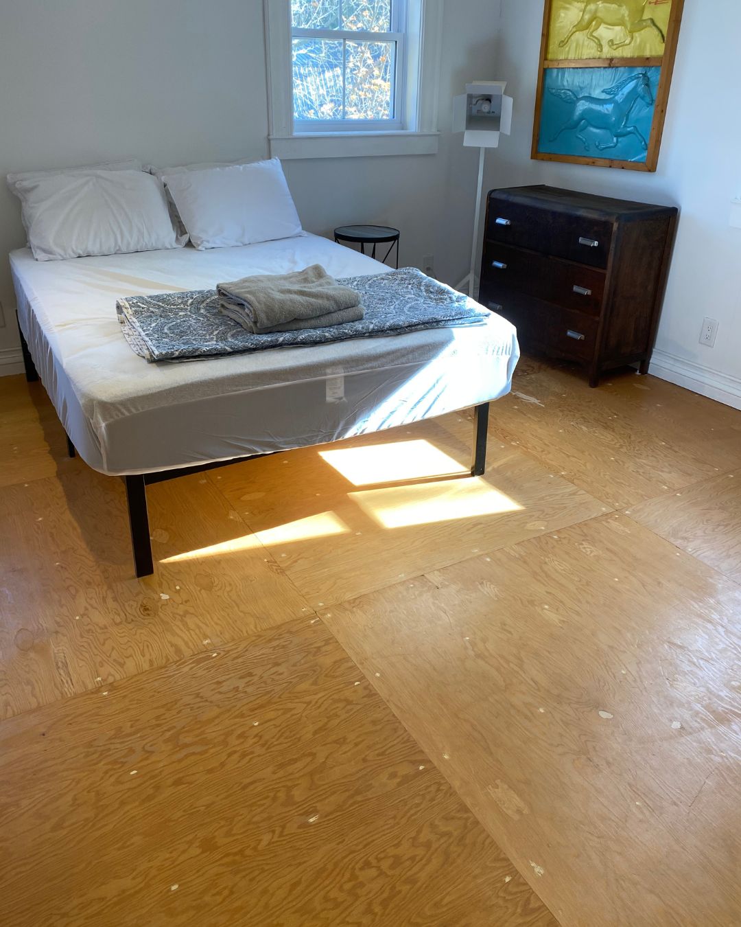 Primary bedroom before staging with bare floors, minimal furnishings, and no cohesive design