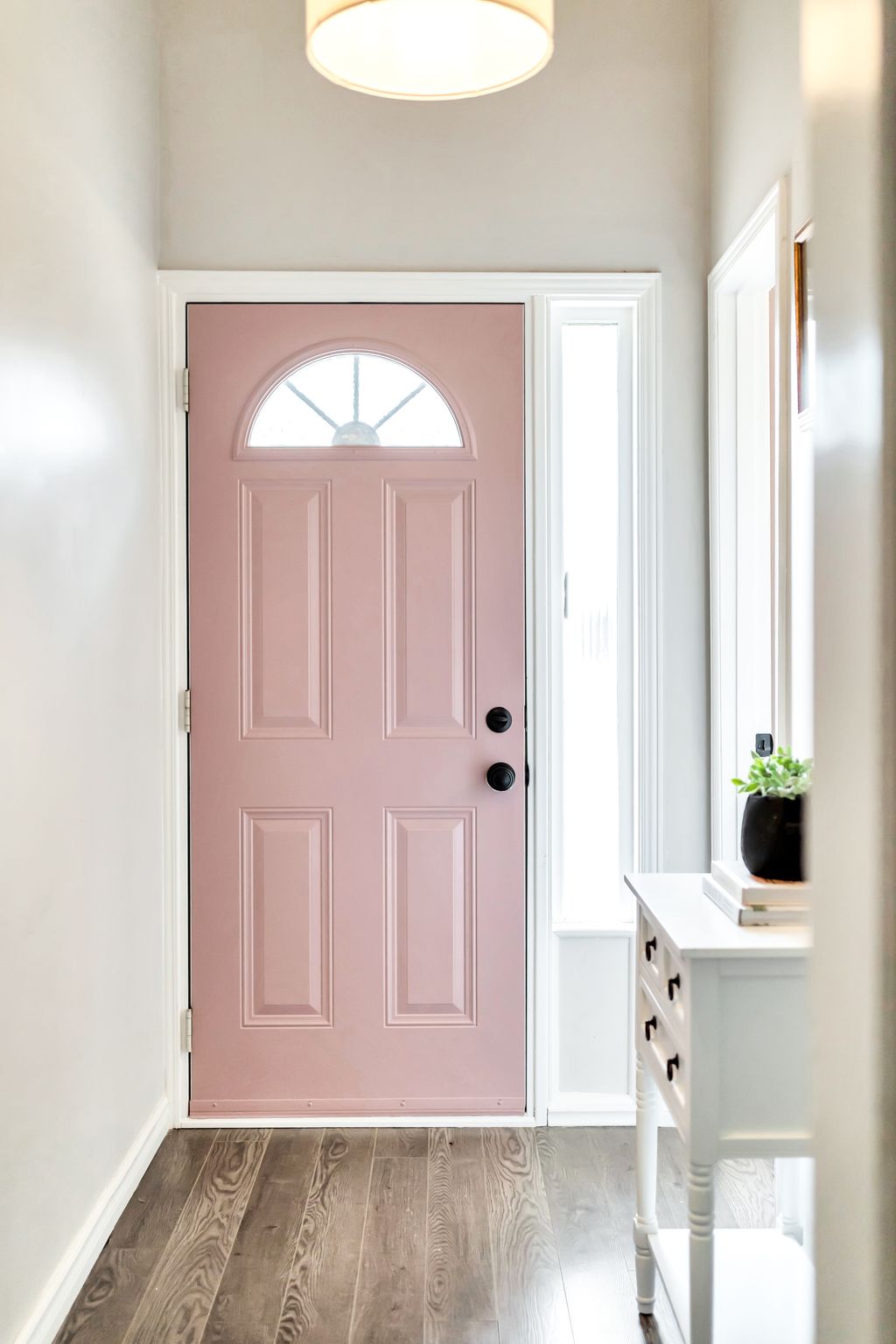 Bright front foyer with updated flooring, modern light fixture, and natural light