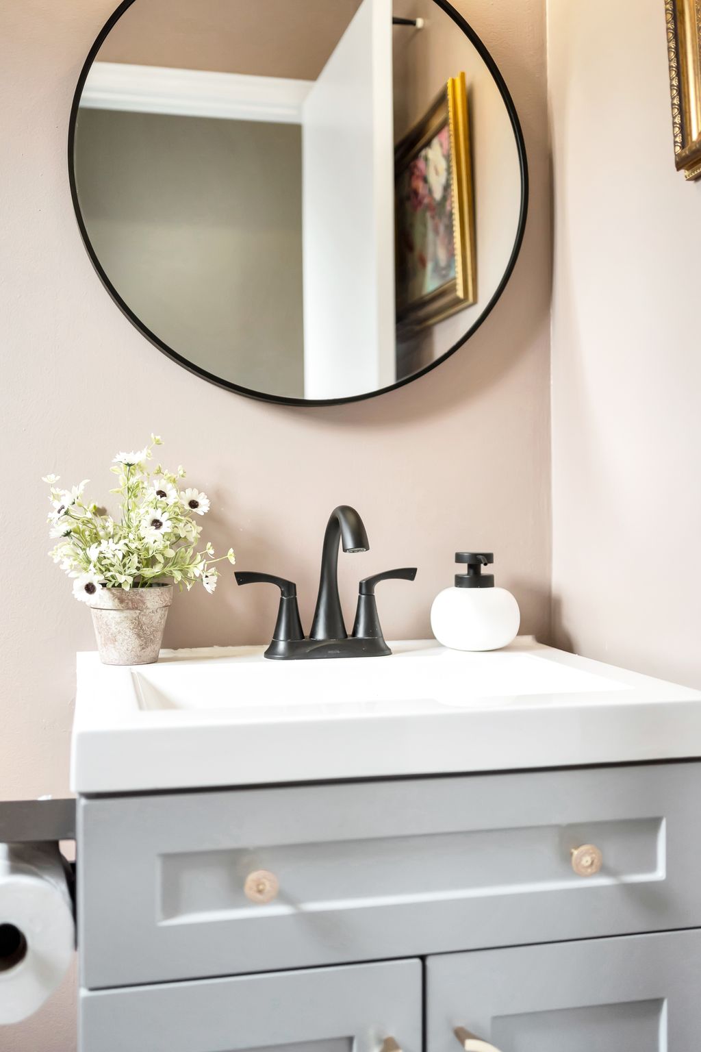 Renovated bathroom with modern vanity, framed mirror, and soft neutral tones