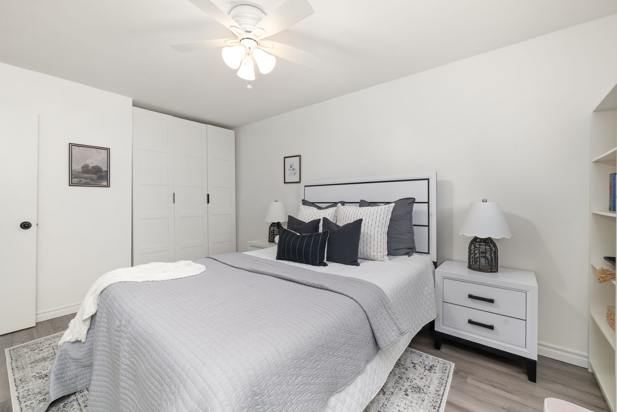 Primary bedroom with plank laminate floors and California shutters