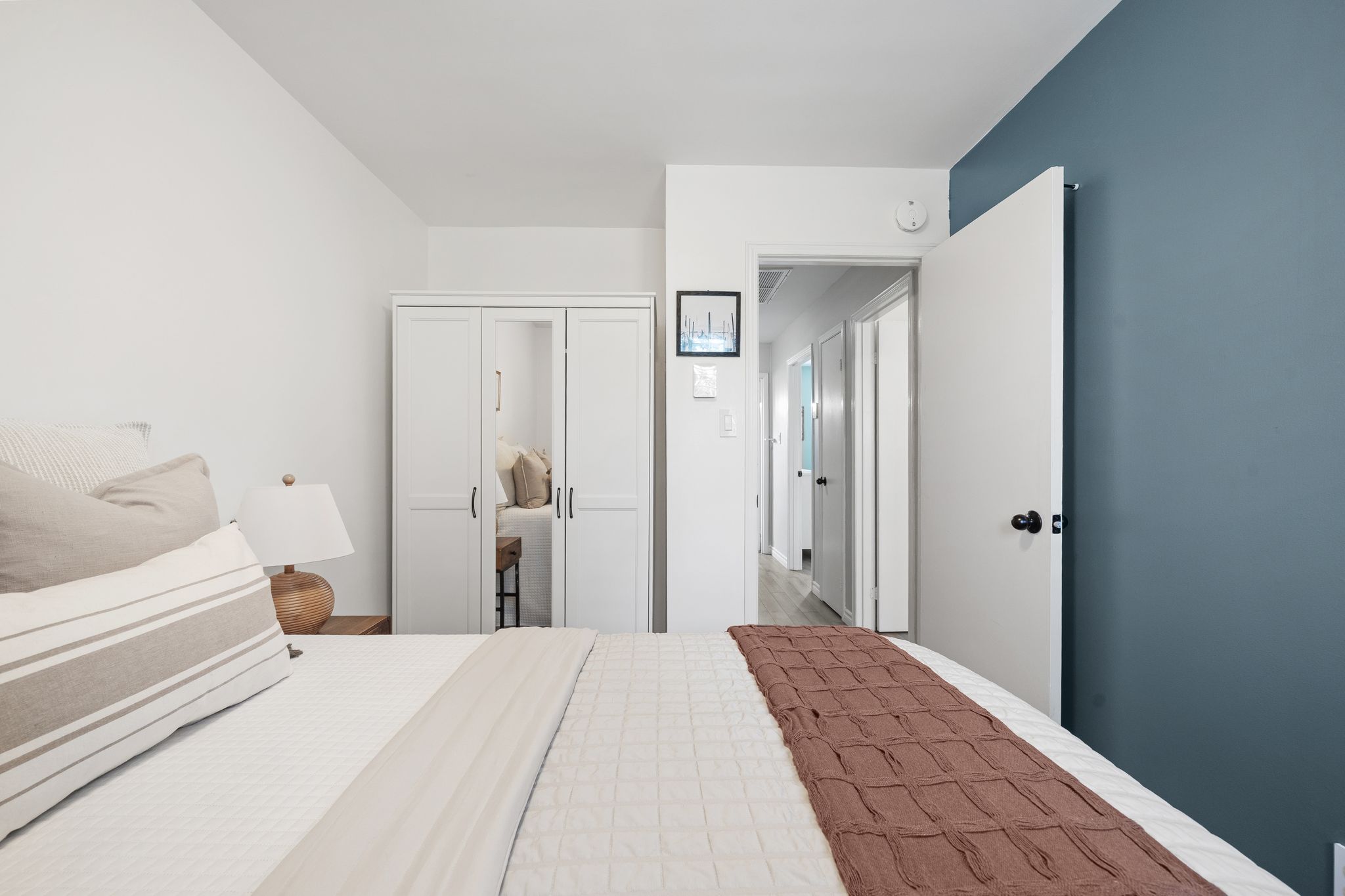 Third bedroom with white wardrobe and view to hallway