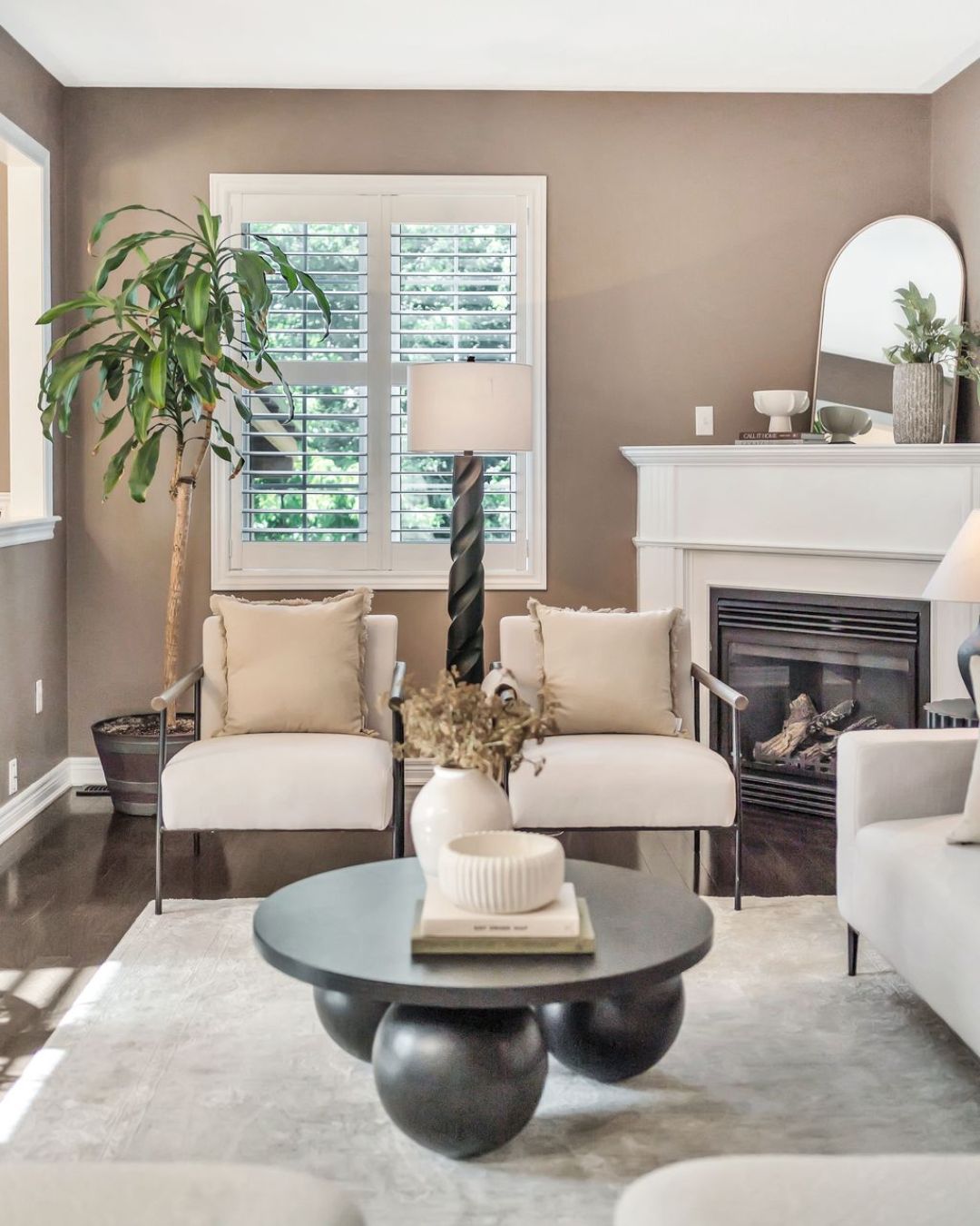 Living room at 14 Sleepy Hollow Place in Whitby with white fireplace, large window with California shutters, neutral furnishings, and modern decor.