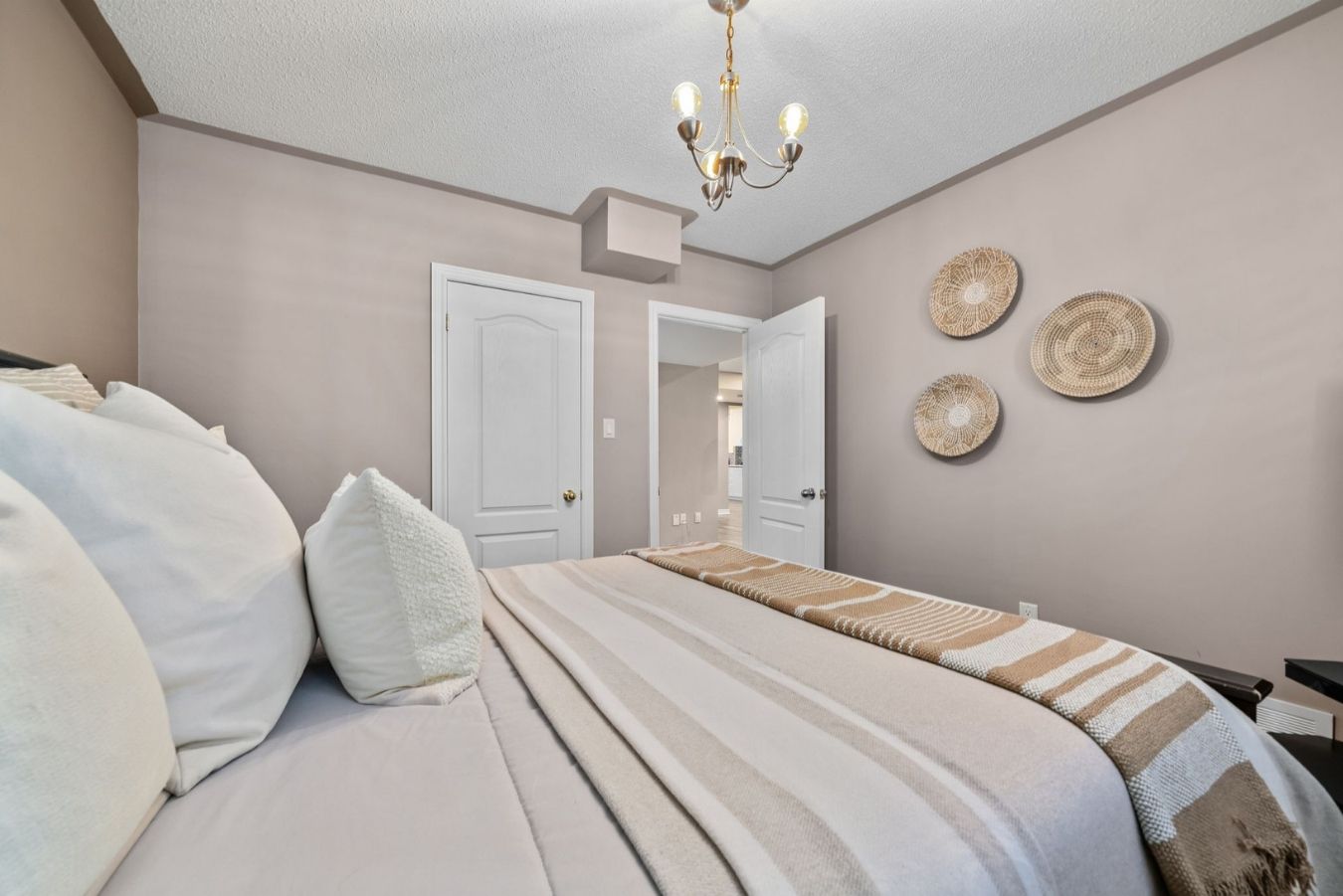 Third bedroom with neutral walls, double-door closet, and cozy bed setup.