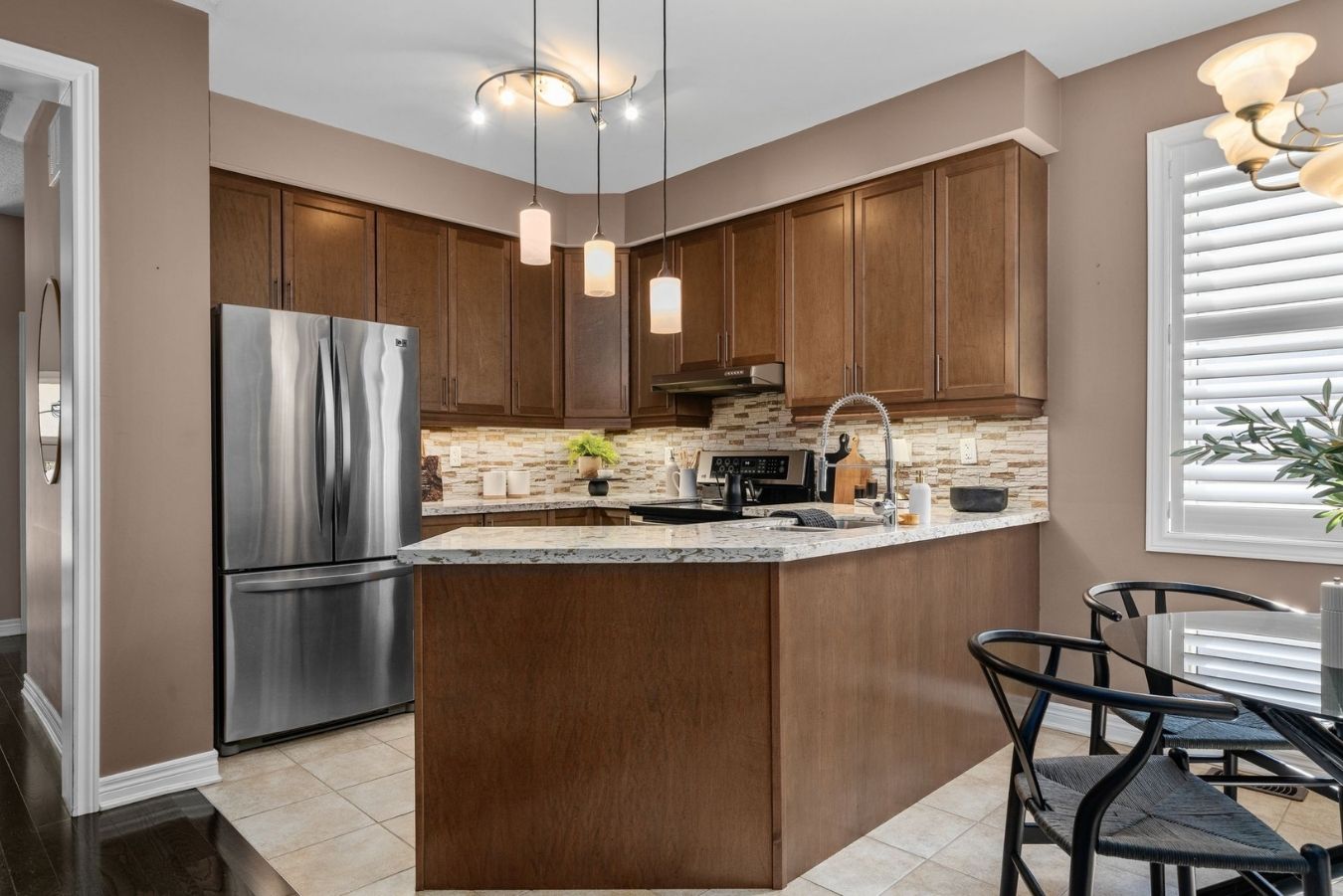 Kitchen at 14 Sleepy Hollow Place in Whitby with stainless steel appliances, maple cabinetry, granite counters, pendant lighting, and a tile backsplash.