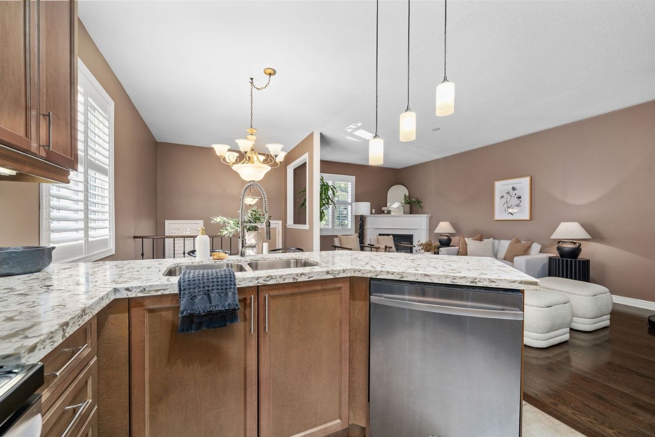 Open-concept view from the kitchen island at 14 Sleepy Hollow Place in Whitby, overlooking the dining area and living room with fireplace.