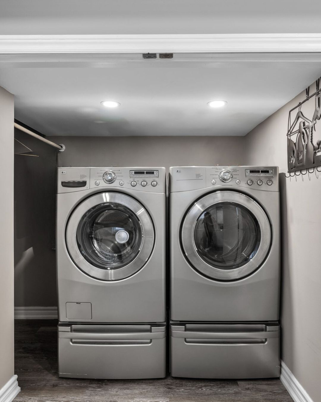 Laundry area with modern front-loading washer and dryer, built-in shelving, and overhead lighting at 14 Sleepy Hollow Place.