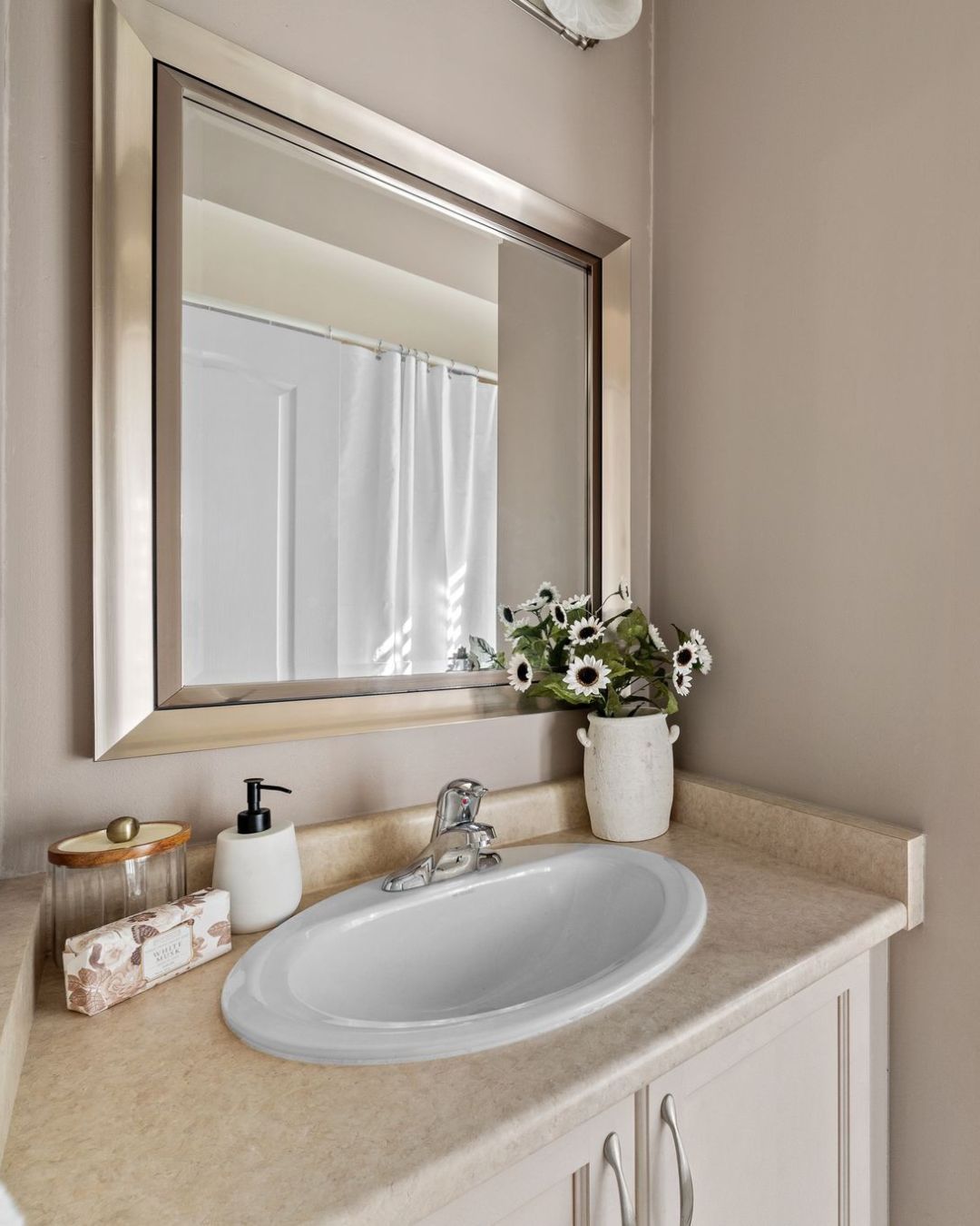 Main bathroom at 14 Sleepy Hollow Place in Whitby with neutral vanity, framed mirror, and decorative accents.