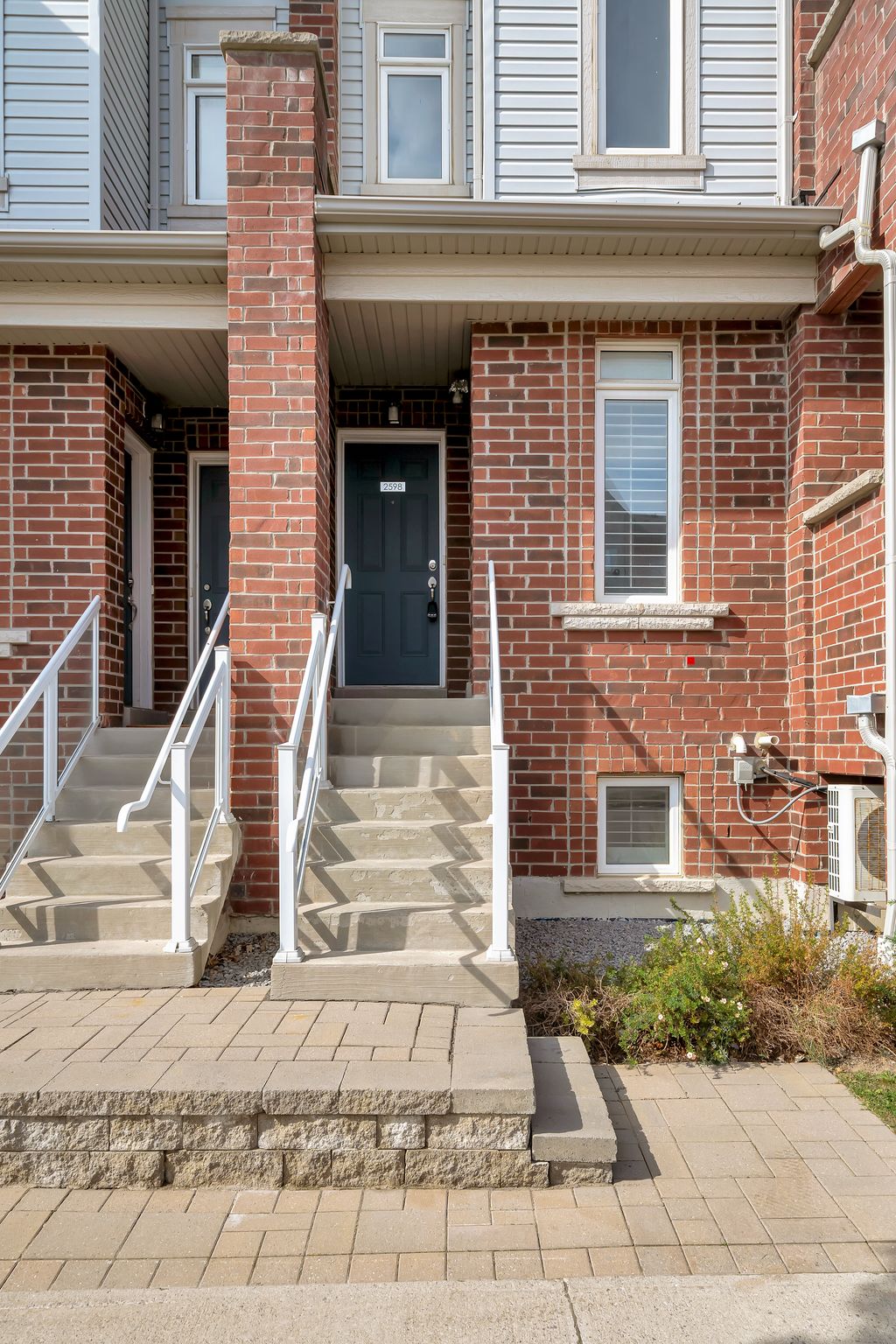 Front exterior of stacked townhouse at 2598 William Jackson Dr Pickering with brick and siding design, steps, and balconies.