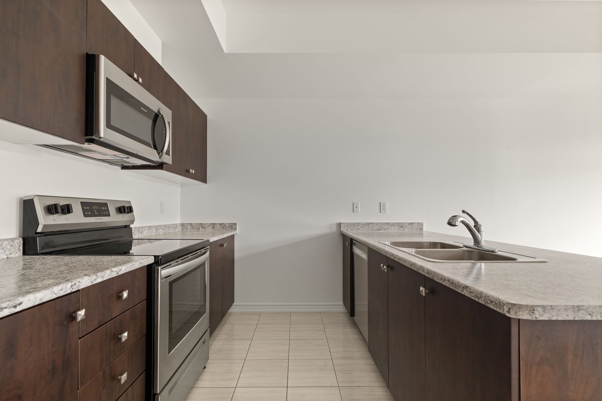 Kitchen with stainless steel appliances and dark cabinetry at 2598 William Jackson Dr Pickering.
