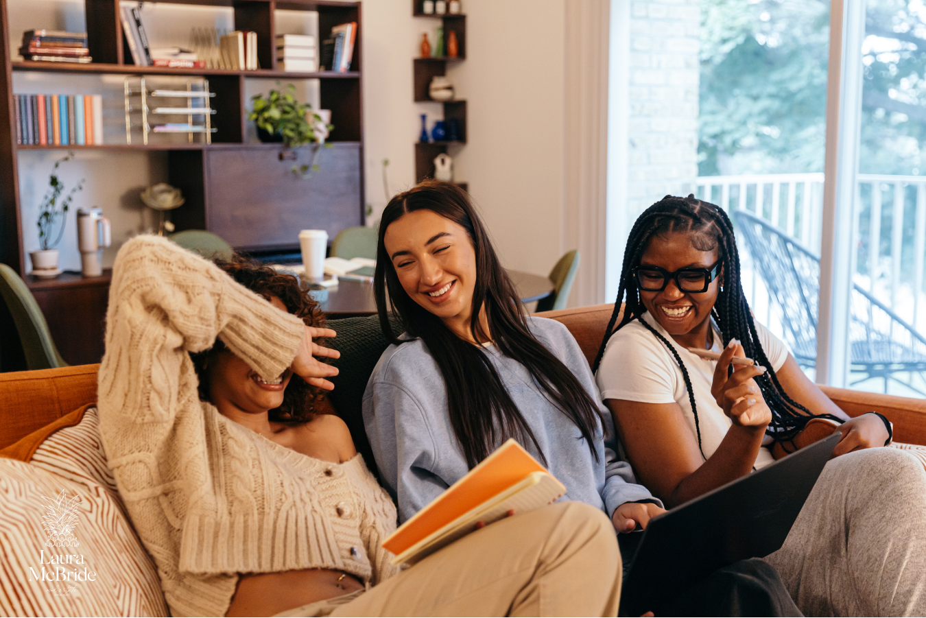 Three friends laughing together at home after buying a house together as co-buyers in the Greater Toronto Area.