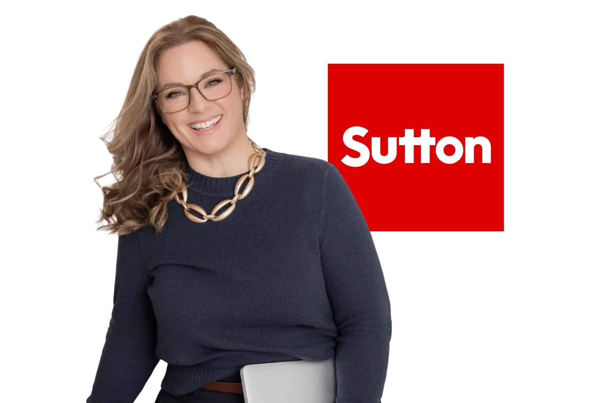 Portrait of Laura McBride, Realtor with Sutton Group, smiling and holding a laptop against a white background with the Sutton logo visible.