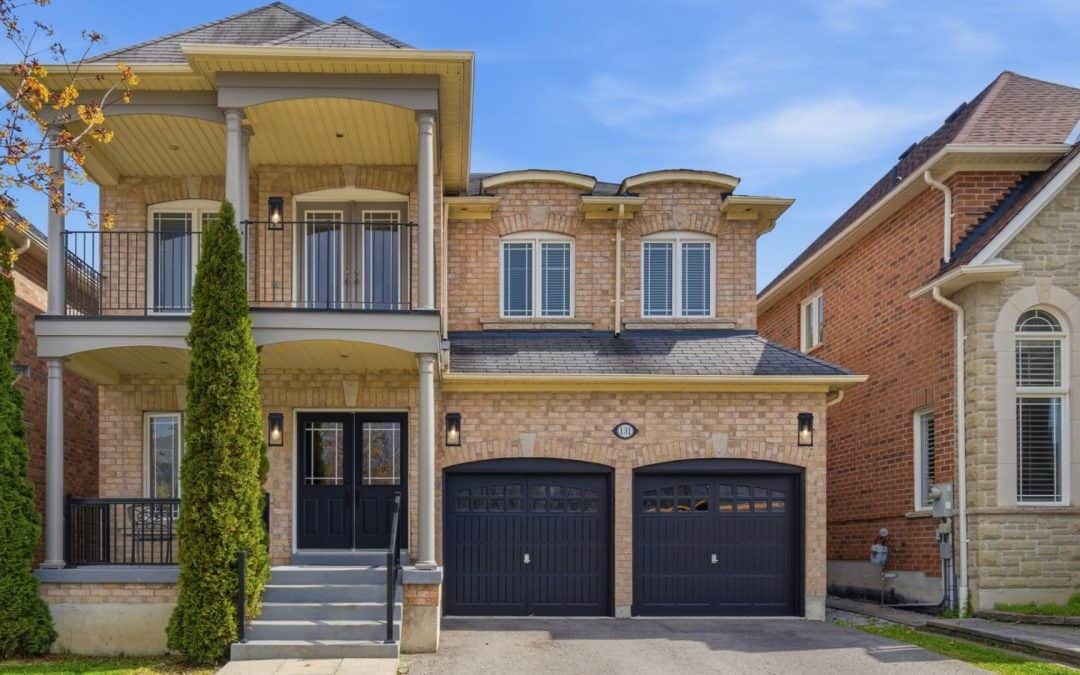 Exterior front view of 131 Rushworth Drive in Ajax with brick façade, covered porch, balcony, and double garage