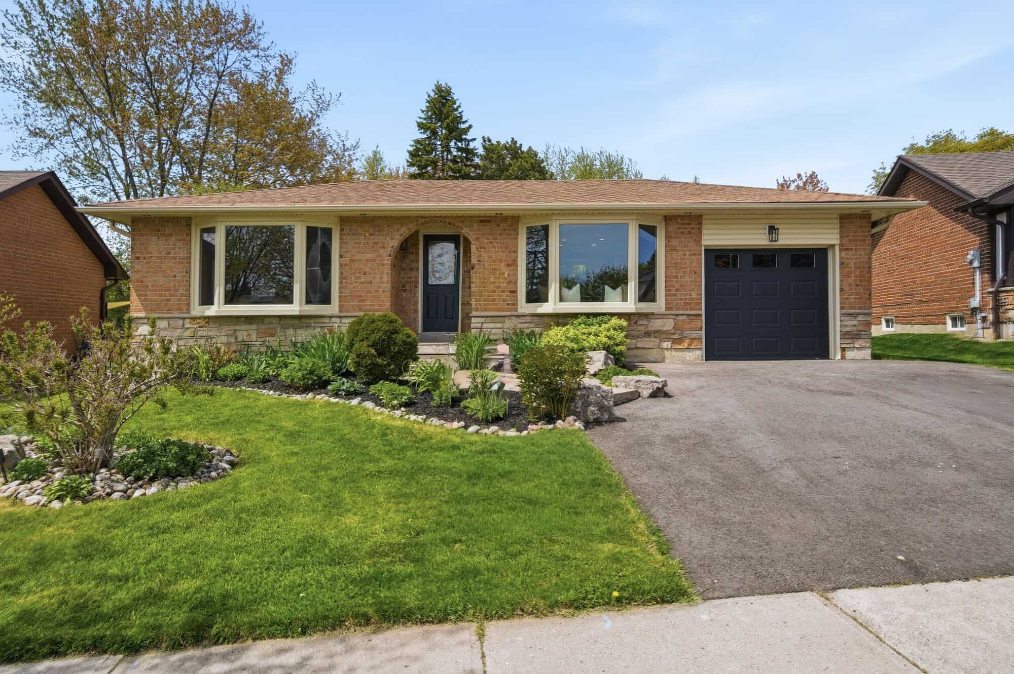Front view of 39 Anstead Crescent, a brick detached Ajax bungalow for sale with landscaped gardens and a garage.