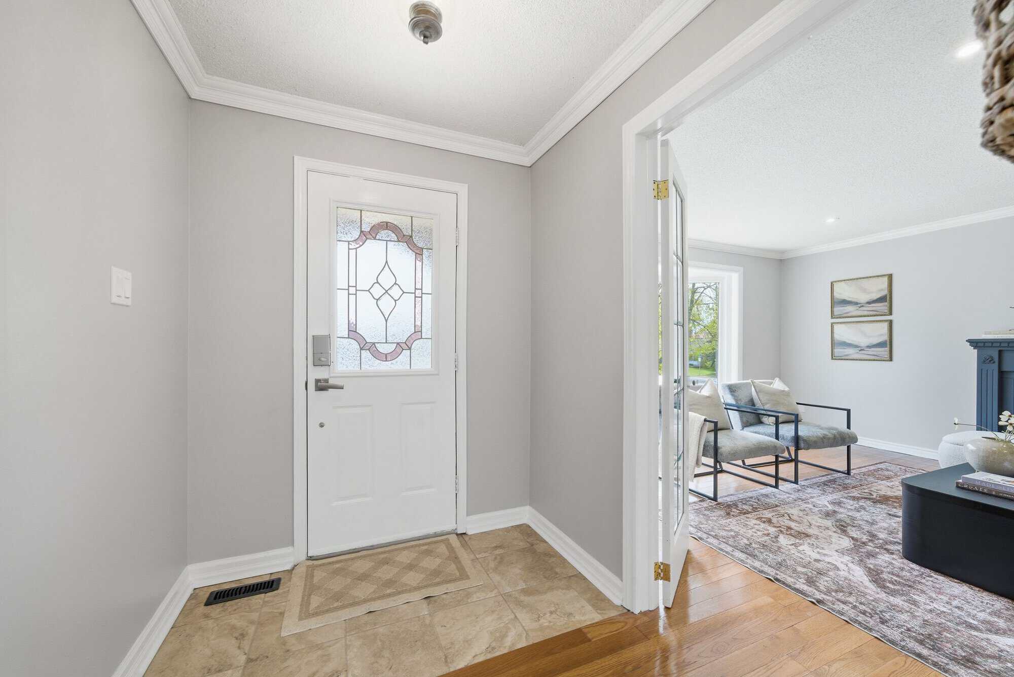 Front entry at 39 Anstead Crescent in Ajax with tile flooring, glass-panel door, and living room access.