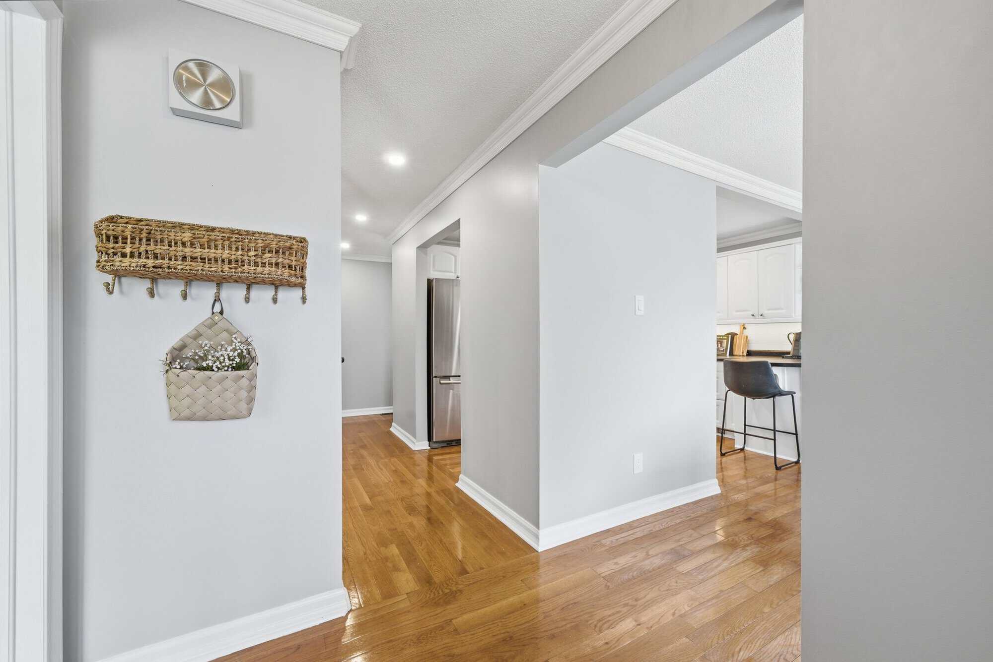 Interior hallway at 39 Anstead Crescent in Ajax with hardwood floors, pot lights, and kitchen access.