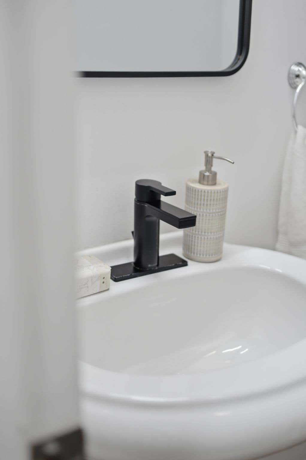 Two-piece bathroom at 13 Flowers Crescent in Ajax with a pedestal sink, black fixtures, storage cabinet and toilet.
