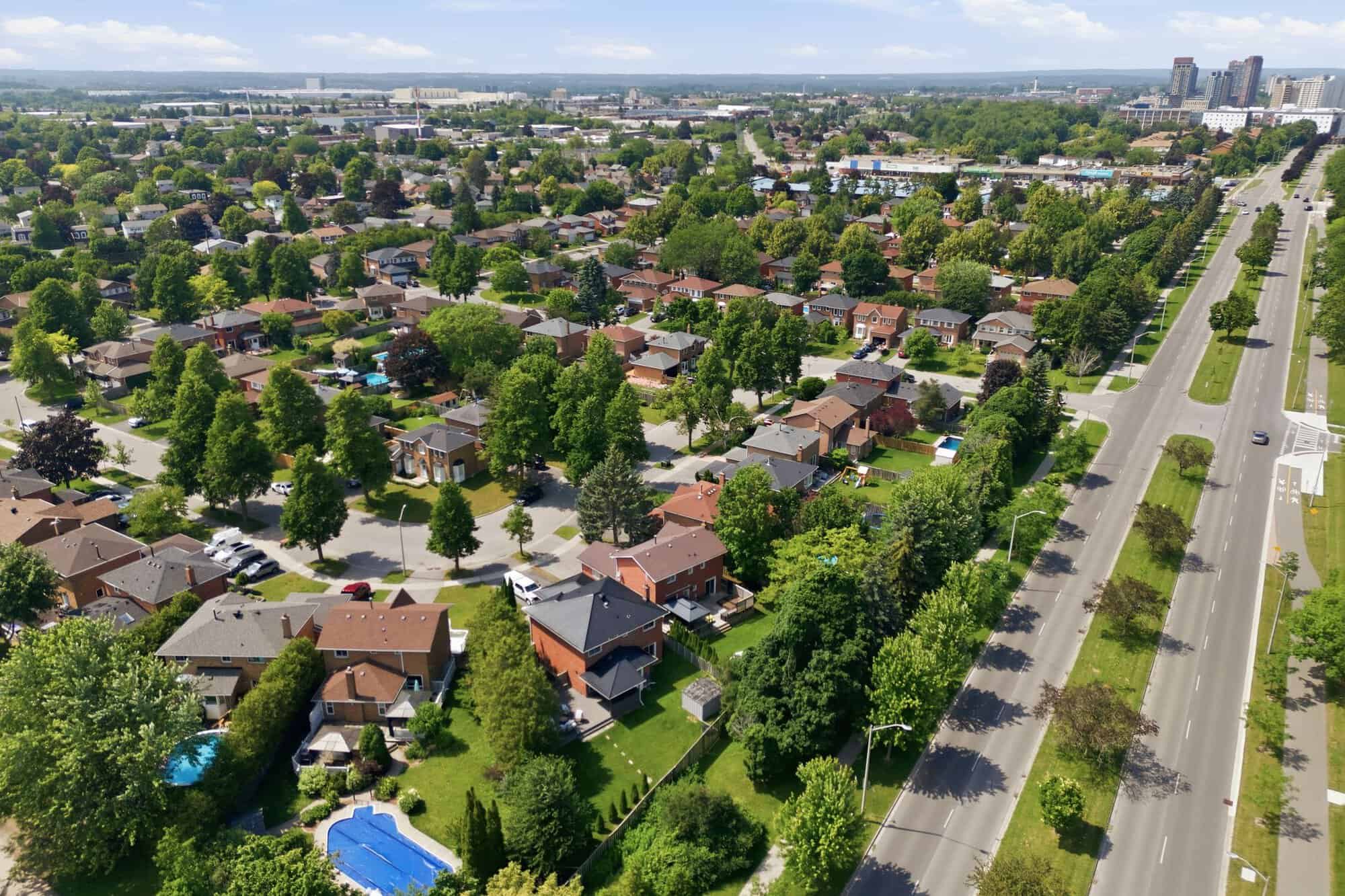 Aerial view of the Ajax neighbourhood surrounding 13 Flowers Crescent, showing residential streets, mature trees, and a nearby multi-lane road.
