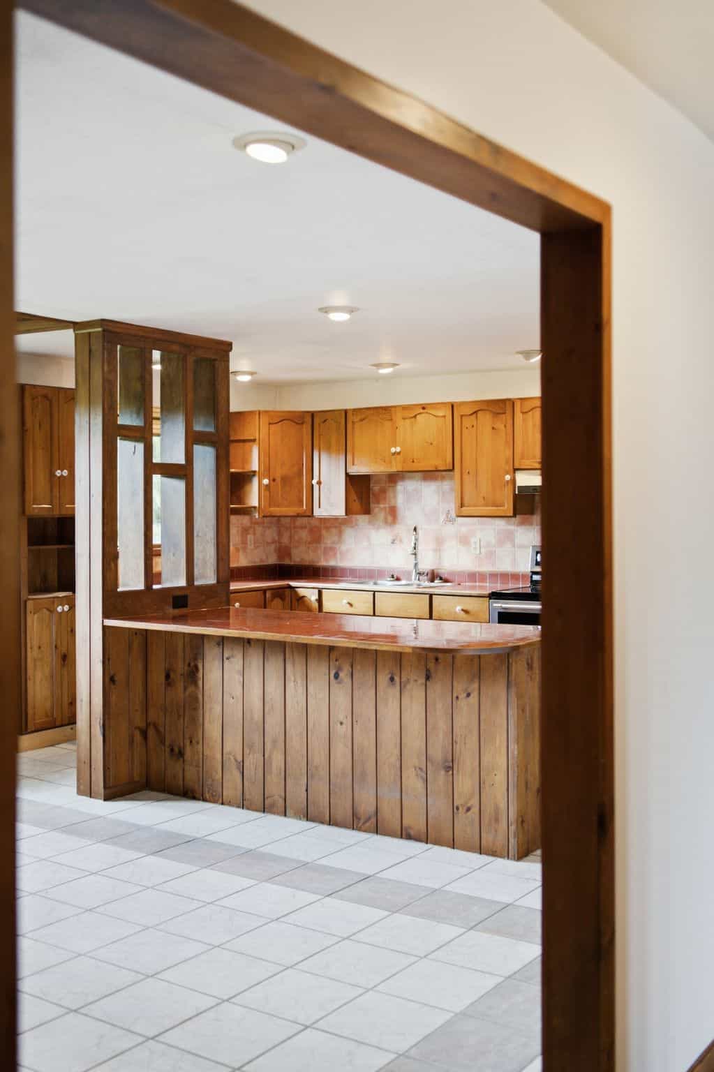 Large eat-in kitchen with extensive wood cabinetry, peninsula seating, tiled flooring, and breakfast area.