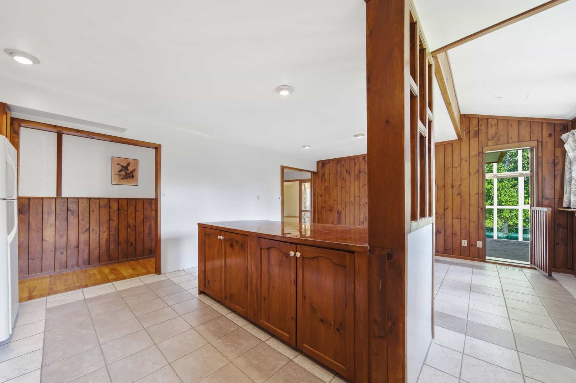 Large eat-in kitchen with extensive wood cabinetry, peninsula seating, tiled flooring, and breakfast area.